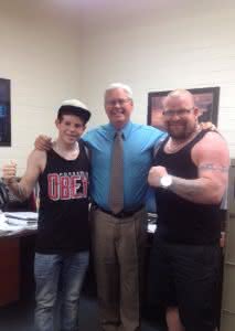 Alex (left) with his father Andre (right) and principal David George.