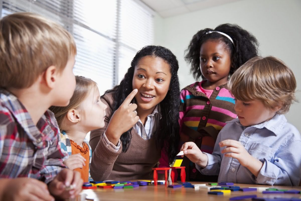 A Leader in Me instructor teaches a group of students using blocks and hand gestures.