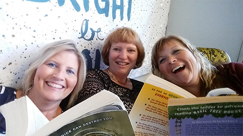 Three Staff Members Reading in the Selfie Scavenger Hunt